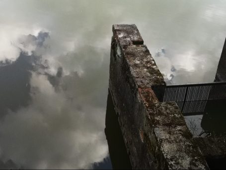 Un mur, le ciel, leur reflet dans l'eau